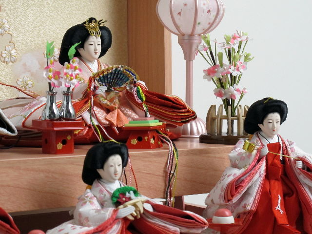 オレンジ女雛とグレー男雛の五人揃いをピンクの宝箱に収めた組み立て簡単のかわいい収納飾りです。