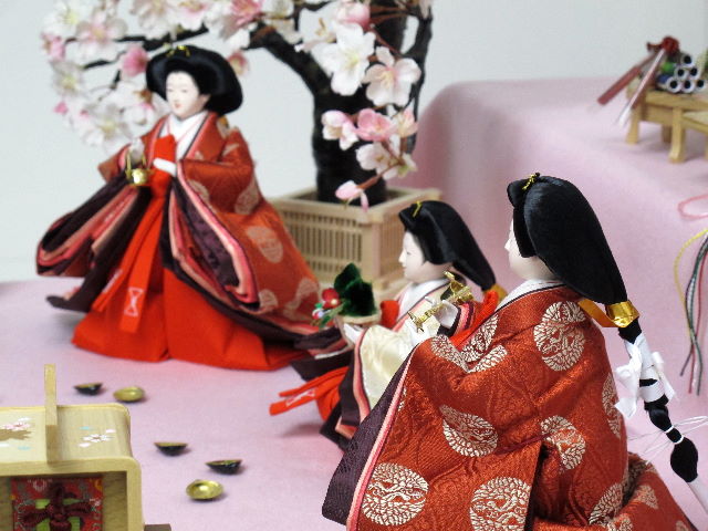 平安貴族の愛用した有職文様、鶴の丸を正絹衣装に織り込み着せ付けた、落ち着いたお雛さまを毛氈を敷いた二段飾りにしました。桐箱に収納します。桜の木が美しい創作雛人形です。