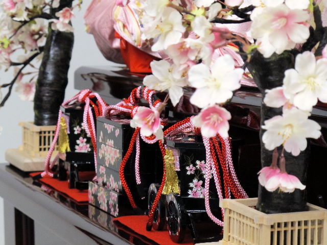 淡い淡いピンクのお雛様を落ち着いた茶塗りの三段に並べました。屏風と台の柄は金桜で重厚な中にも華やかさがあります。