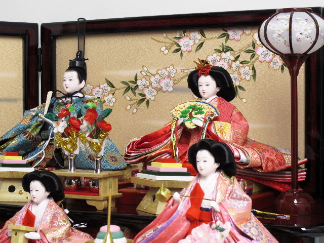 やわらかい桃色の女雛とやさしい緑色の男雛の組み立て式の三段飾りです。ボリューム感がある間口70cm以下で飾れる雛人形です。