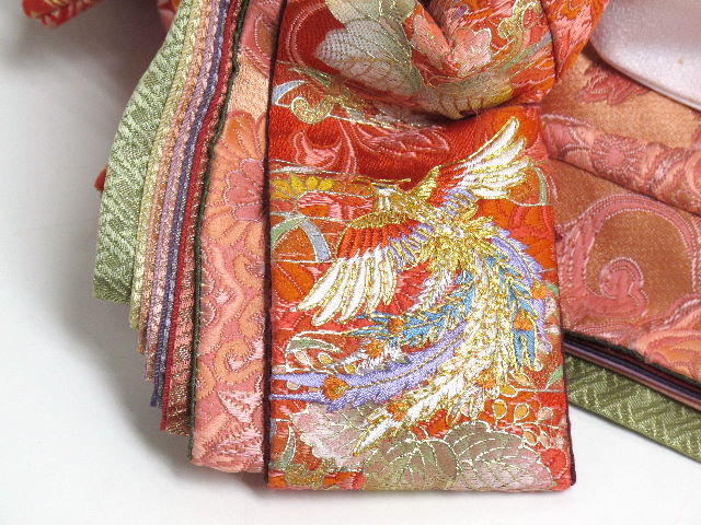 女雛は赤主体、男雛は緑主体の衣装地で、平安（心穏やかな様子）を意味する伝説の神獣『鳳凰』の京刺繍が施されています。