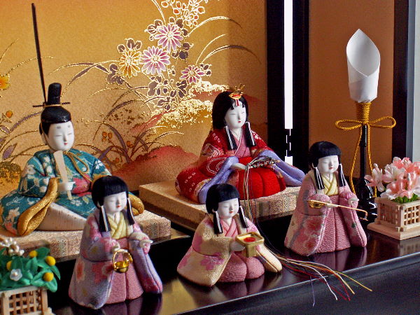 パステルカラーの衣装をかわいい小さな雛人形に木目込んだコンパクト収納式5人飾り人形が並んだところ