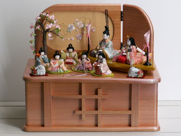 ピンクの収納台ににぎやかに並ぶ木目込み雛人形7人収納飾り