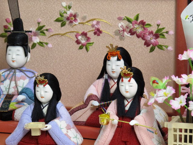 パステルカラーの衣装がかわいい木目込み人形の五人飾りです。桜柄の刺繍がポイントのピンク色の収納台に飾りました。