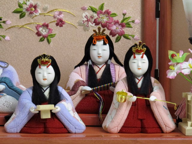パステルカラーの衣装がかわいい木目込み人形の五人飾りです。桜柄の刺繍がポイントのピンク色の収納台に飾りました。