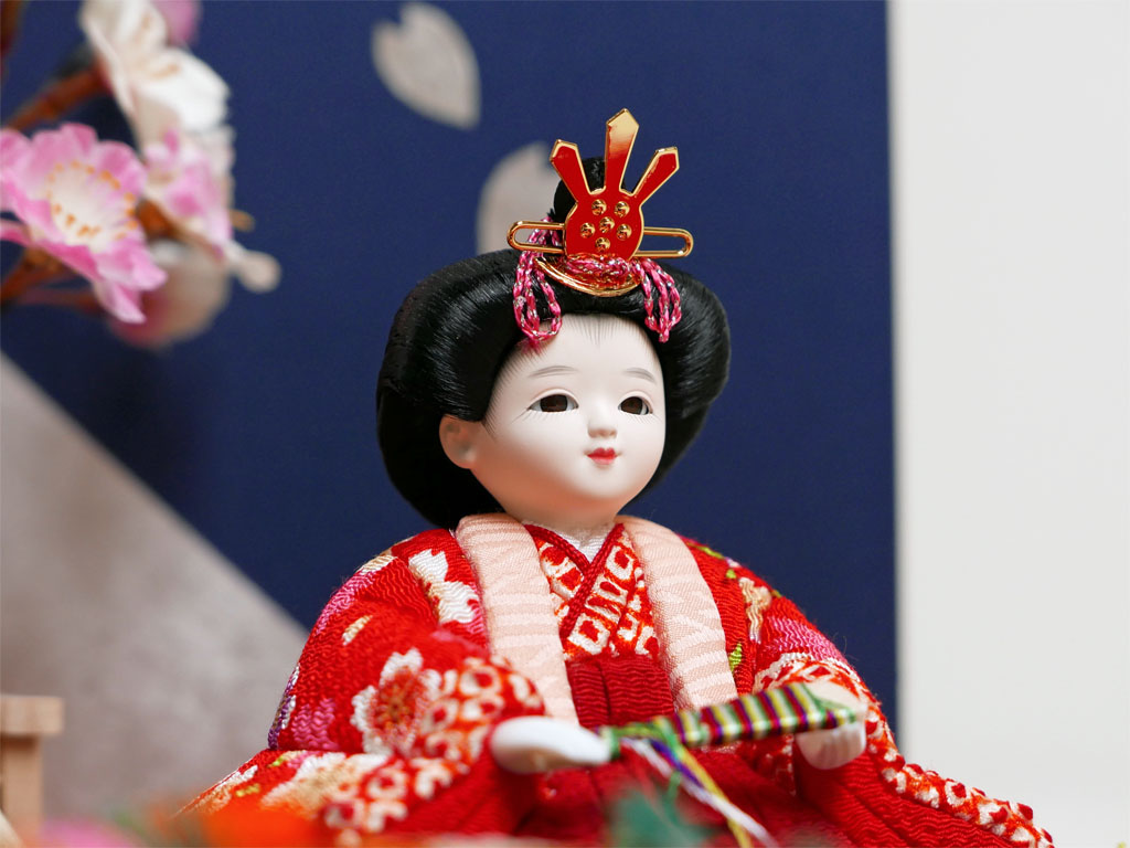 ぱっちりとした目が可愛い赤い衣装の木目込み人形金銀箔船盛桜飾り
