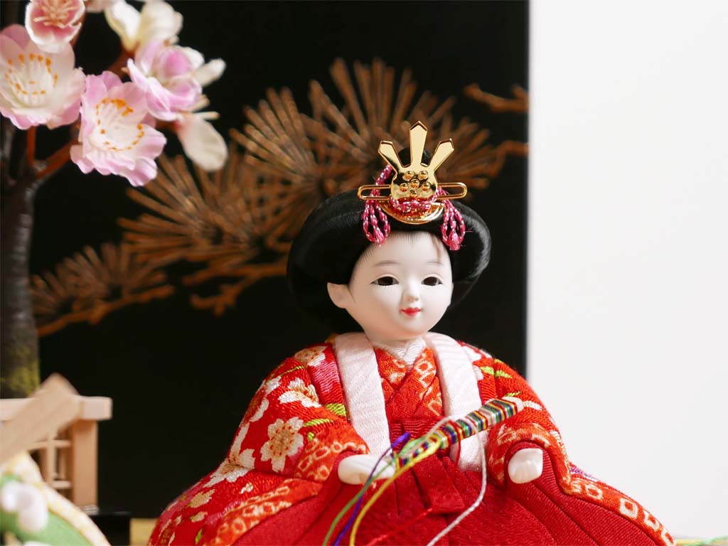 ぱっちりとした目が可愛い赤い衣装の木目込み人形金彩月に松コンパクト収納飾り