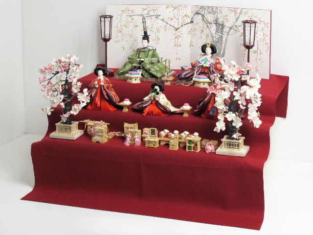 伝統的な有職文様雛を沢山の嫁入り道具と飾る桐箱収納三段毛氈飾り