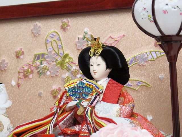 女雛はピンク、男雛は白を基調とした有職文様衣装を着せ付けた人形で、のしめ柄刺繍の赤塗り箱に納めました。