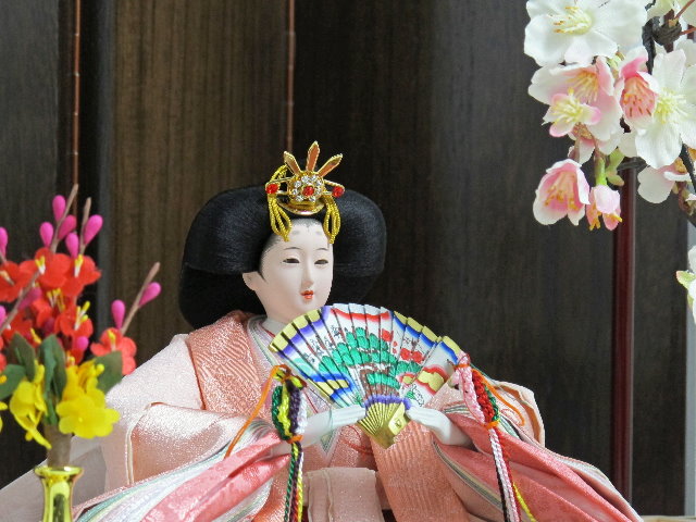 桜色のおひなさまを茶塗り台に置いて、両脇に豪華な桜を並べた親王飾りです。
