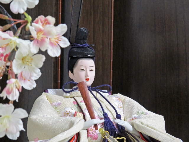 桜色のおひなさまを茶塗り台に置いて、両脇に豪華な桜を並べた親王飾りです。